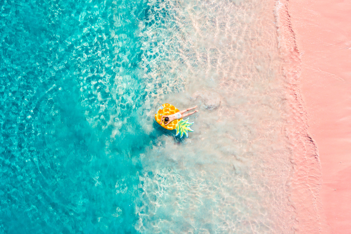 a girl floating around the coast of Pink Beach